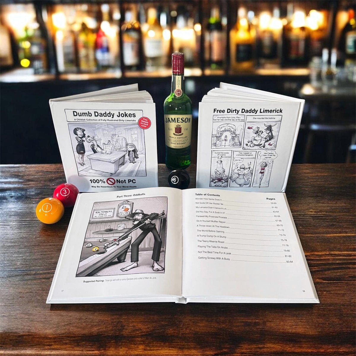 Dumb Daddy Jokes hardcover displayed at a bar with a bottle of Jameson and pool balls
